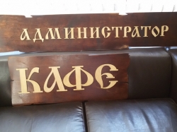 Гравировка текста на деревянной табличке для кафе